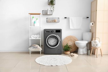 Modern çamaşır makinesiyle aydınlık banyonun içi