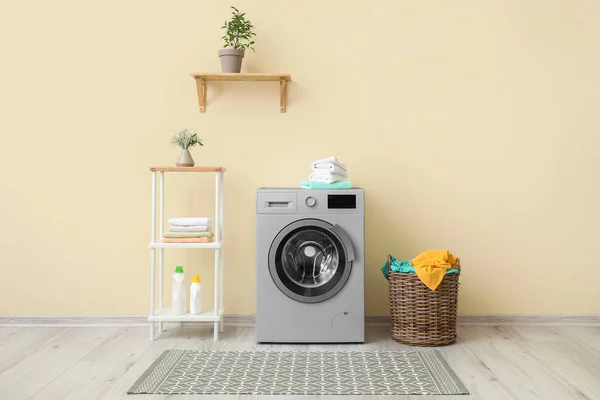 Interior of modern home laundry room with washing machine, basket and shelving unit