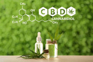 CBD yağı şişeleri ve açık havada yapraklar.