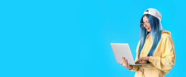 Uzun mavi saçlı havalı genç kadın dizüstü bilgisayarını arka planda tutuyor ve mesaj için yeri var.