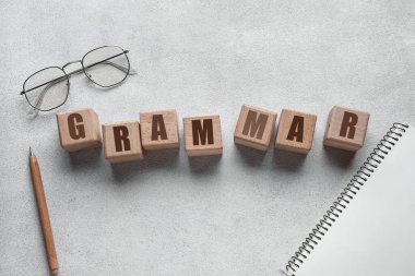 Kelime GrammaR ışık arkaplan üzerinde küp, gözlük, kalem ve defterden yapılır