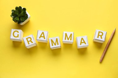 Kelime GrammaR sarı zemin üzerinde küp ve kalem yapılır