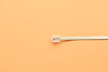 Turuncu arka planda beyaz internet kablosu, yakın plan