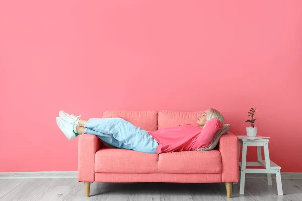 Starší Žena Relaxační Pohovce Blízkosti Růžové Zdi — Stock fotografie
