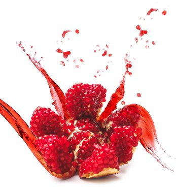 Ripe pomegranate and splash of juice isolated on white