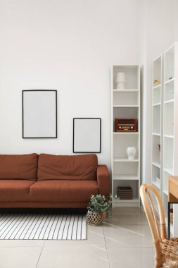 Kanepesi ve raf ünitesi olan modern oturma odasının içinde.