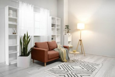 Oturma odasının içinde kanepe ve raf üniteleri var.