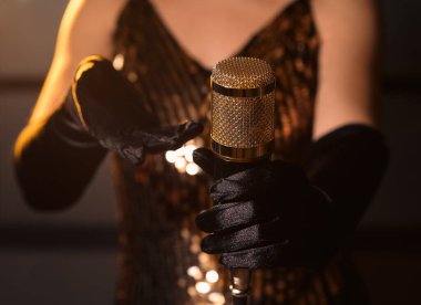 Profesyonel mikrofon tutan kadın şarkıcı, yakın plan.