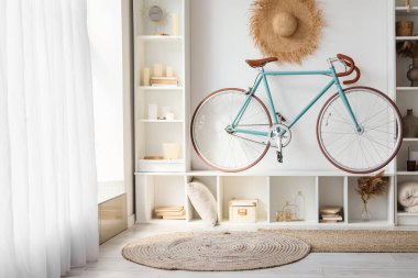 Interior of modern living room with bicycle and white shelving unit