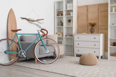 Bisiklet, sörf tahtası ve çekmeceli modern oturma odası.