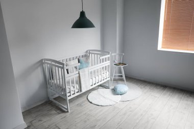 Rahat beşiği ve sandalyesi olan hafif çocuk odasının içinde.