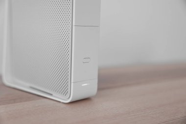 Modern beyaz wi-fi yönlendirici ışık duvarının yanındaki masada, yakın plan