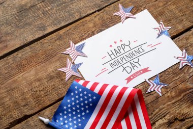 Greeting card with text HAPPY INDEPENDENCE DAY, stars and USA flag on wooden background