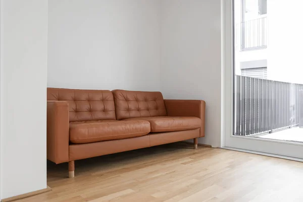 部屋のライトウォールの近くの茶色いソファ — ストック写真