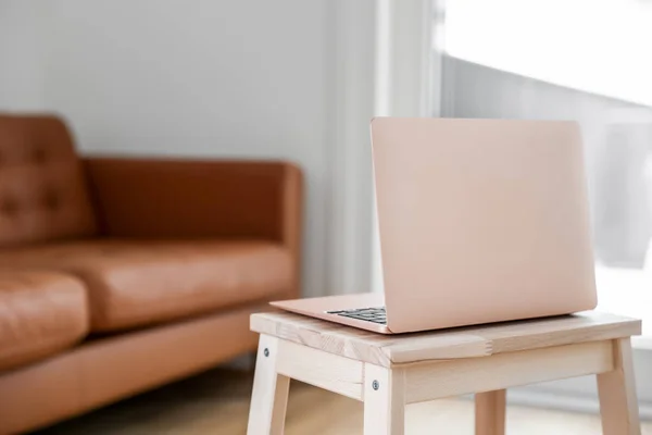 Modern laptop on step stool in living room, closeup
