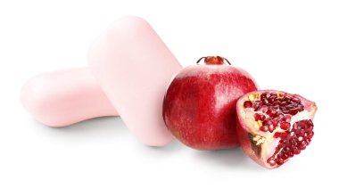 Beyaz zemin üzerinde sabun çubukları ve olgun nar.