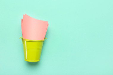 Renk arkaplanı üzerine boş yapışkan notlara sahip çöp kutusu