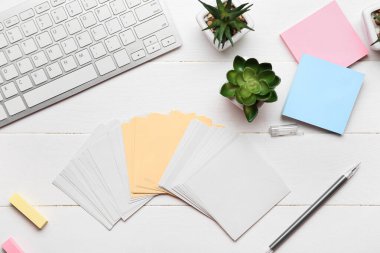 Boş yapışkan notlar, ev bitkileri, beyaz ahşap arka planda kalem ve klavye