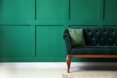 Yeşil duvarın yanındaki şık kanepe