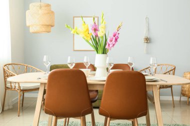 Güzel masa düzeniyle ve Gladiolus çiçekleriyle dolu bir oda.