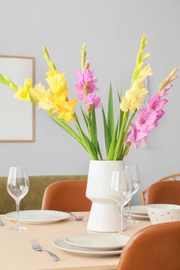 Odasında güzel Gladiolus çiçekleri olan şık bir masa.