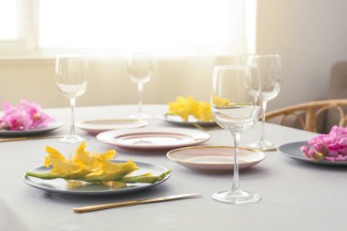 Güzel bir sofra, boş bardaklar ve Gladiolus çiçekleri.