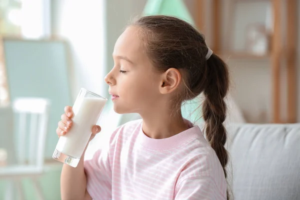 小女孩在家里的沙发上喝牛奶 — 图库照片