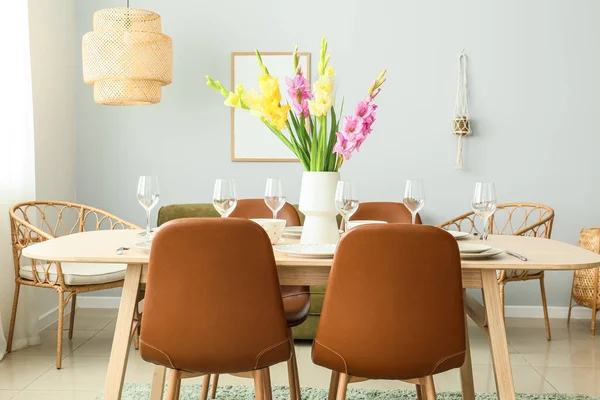 Güzel masa düzeniyle ve Gladiolus çiçekleriyle dolu bir oda.