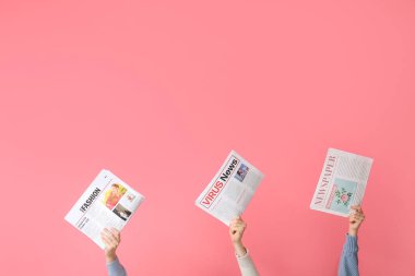 Pembe arka planda gazete tutan insanlar