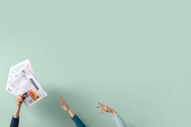 Yeşil arka planda gazeteleri olan insanlar