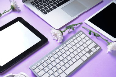 Tablet bilgisayarlı dizüstü bilgisayar, klavye ve leylak arkaplanda çiçekler