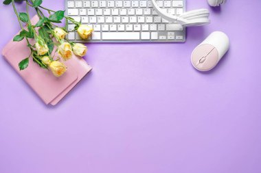 Fare, kulaklık, güller ve eflatun arkaplan üzerine not defteri olan bilgisayar klavyesi