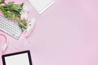 Pembe arka planda çiçekleri olan modern cihazlar