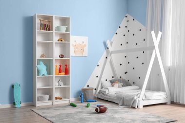 Interior of children's room with modern furniture and rugby ball on floor