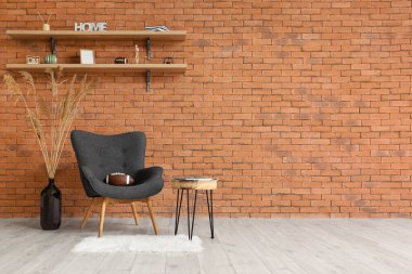 Rugby ball on armchair near brick wall in room