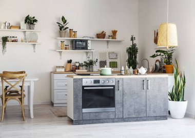 Işık duvarının yanında modern mobilya ve tahta döşeli aydınlatma mutfağı.