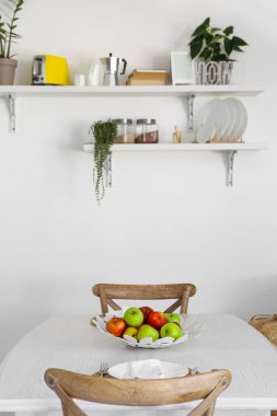 Mutfaktaki yemek masasında elmalı meyve sepeti.