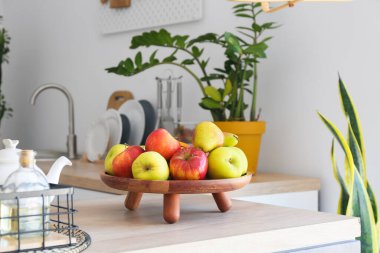 Mutfaktaki ahşap tepside taze meyveler var.