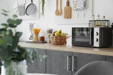 Mutfaktaki mutfak tezgahında meyve ve mutfak malzemeleriyle dolu bir sepet.