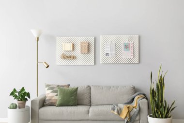 Gri duvarın yanında rahat bir kanepe. Oturma odasının içinde tahtalar var.