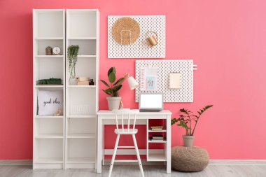 Çalışma odası ve raf üniteleri renkli duvarın yanında.