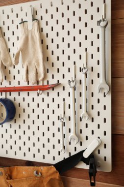 Ahşap duvarda modern aletler olan tahta tahta pano, yakın plan.