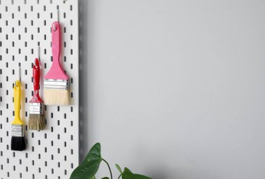 Işık duvarında boya fırçası olan tahta, yakın plan.