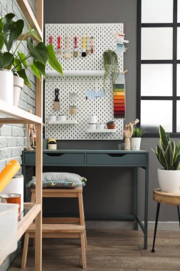 Dekoratörün iş yeri. İç mekandaki gri duvarın yanında farklı aletler var.