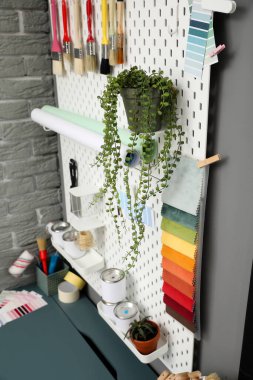 Tahtada ev bitkileri ve teneke boya kutuları var. Yakın plan.