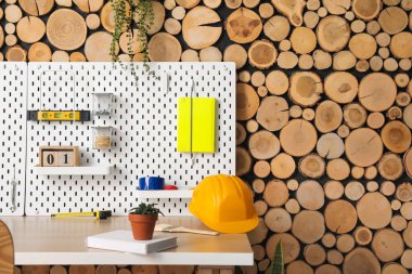 Tahta tahtalar ve atölyede ahşap duvarın yanında farklı aletlerle rahat bir iş yeri.