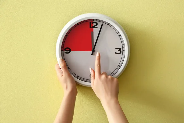 Female Hands Touching Clock Yellow Wall —  Fotos de Stock