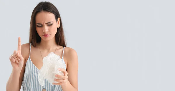 Thoughtful Young Woman Raised Index Finger Holding Plastic Light Background — Foto de Stock