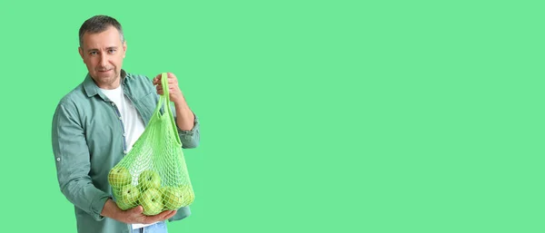 テキストのためのスペースと緑の背景にリンゴとメッシュバッグを保持熟女 廃棄物ゼロコンセプト — ストック写真