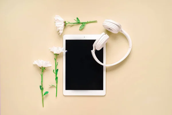 Tablet Computer Headphones Flowers Beige Background — Stock Photo, Image